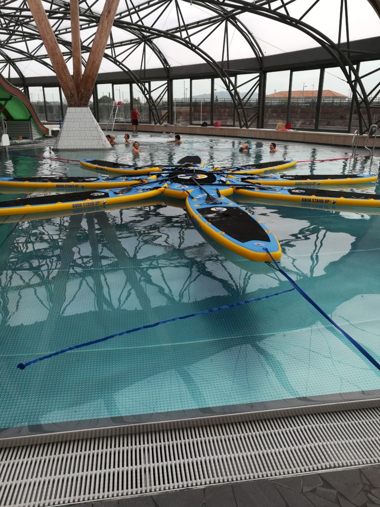 8 planches d'aqua stand up paddle accrochées en rond autour d'une plateforme